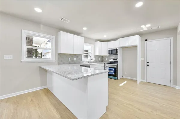 a kitchen with stainless steel appliances granite countertop a refrigerator sink and cabinets