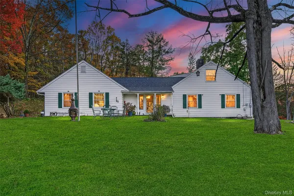 a view of a yard in front of a house with plants and large tree