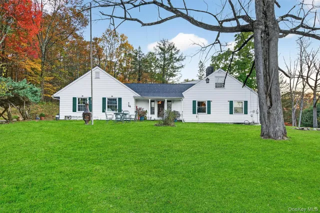 a view of a house and a yard with a large tree