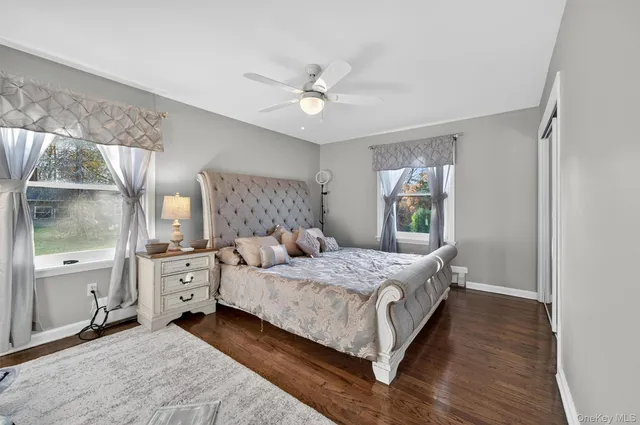 a bedroom with a bed and large windows