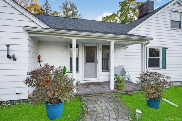a front view of a house with potted plants