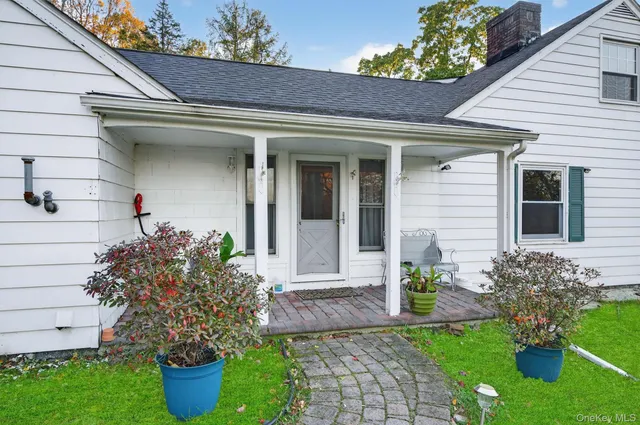 a front view of a house with potted plants