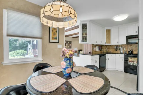 a kitchen with a sink a stove a dining table and chairs
