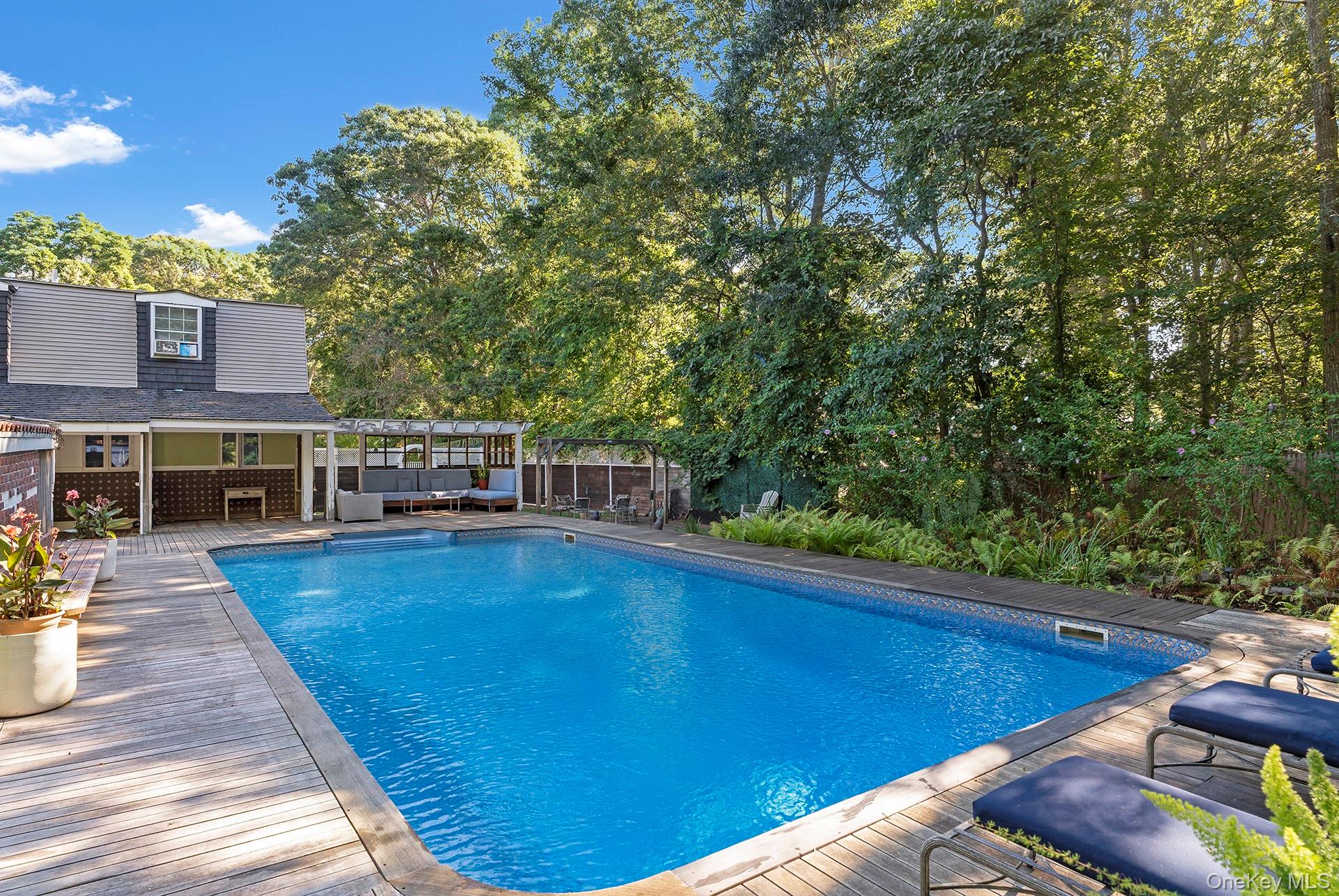 18 Glade Road Springs, NY 11937 - Photo 11 of 12 a view of a swimming pool with seating space