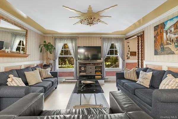 a living room with furniture a large window and a flat screen tv