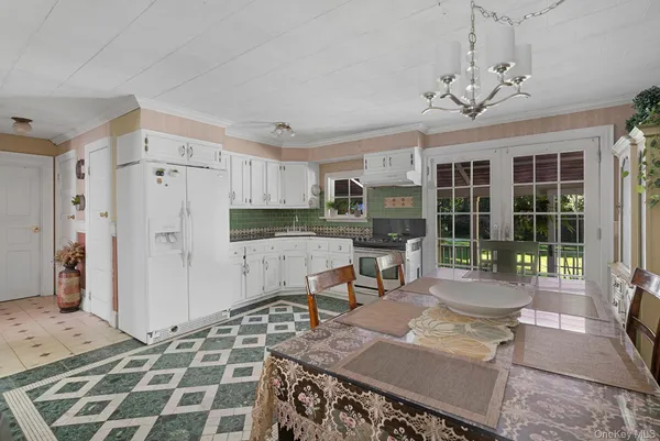 a kitchen with stainless steel appliances granite countertop a stove a refrigerator a sink a dining table and chairs with wooden floor