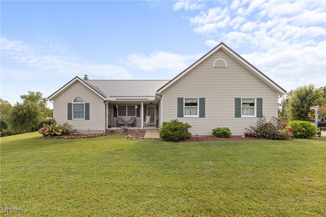 40885 Mt Hope Road Flushing, OH 43977 - Photo 1 of 50 View of front facade featuring a front lawn, a metal roof, and covered porch