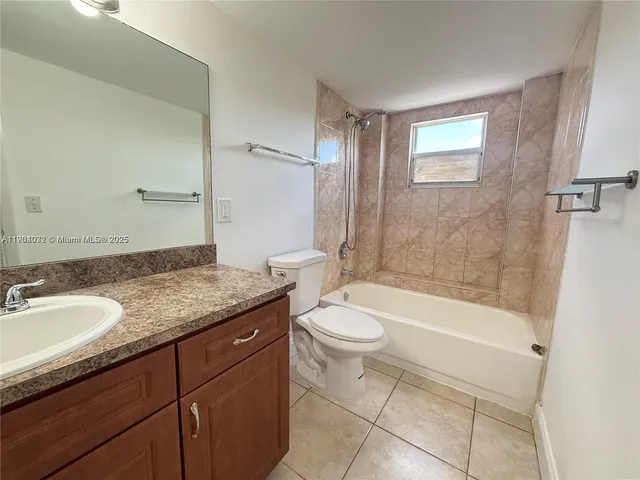 a bathroom with a granite countertop sink toilet mirror and bathtub