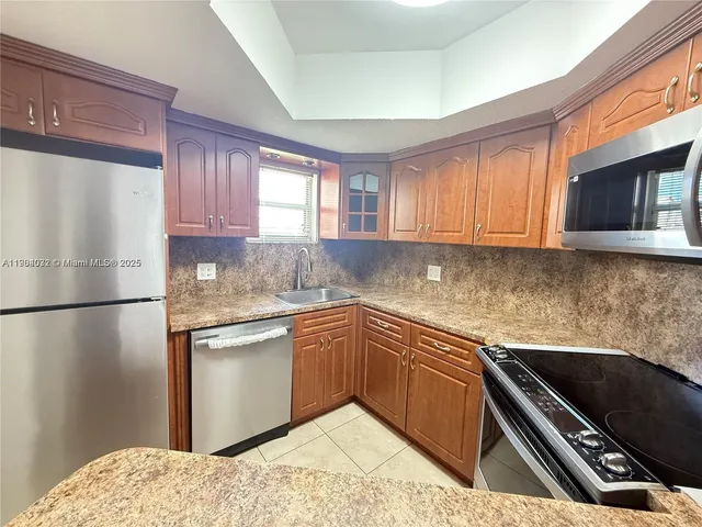a kitchen with a refrigerator sink and cabinets