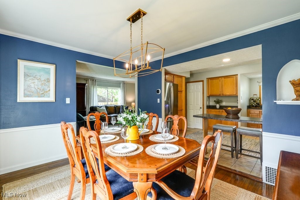 2340 Canterbury Road University Heights, OH 44118 - Photo 9 of 29 Dining area with crown molding, a chandelier, and wood finished floors