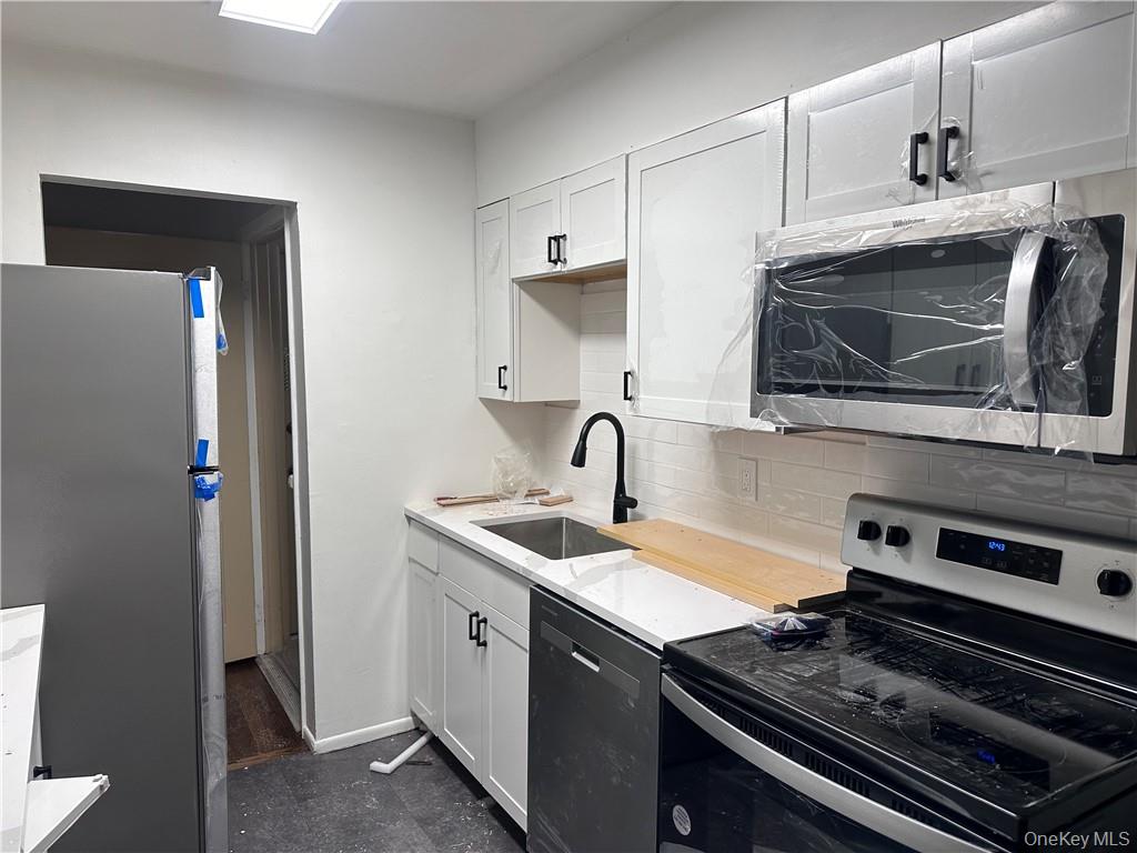 60 Trafalgar Road, Unit 1 New Windsor, NY 12553 - Photo 4 of 7 a kitchen with stainless steel appliances a sink stove and microwave