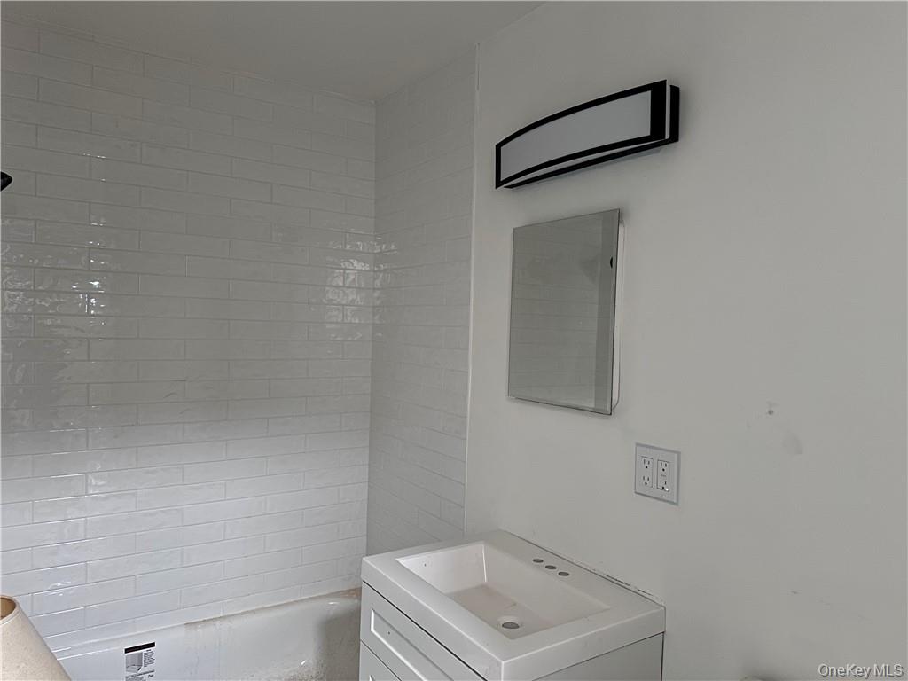 60 Trafalgar Road, Unit 1 New Windsor, NY 12553 - Photo 7 of 7 a bathroom with a shower sink and vanity