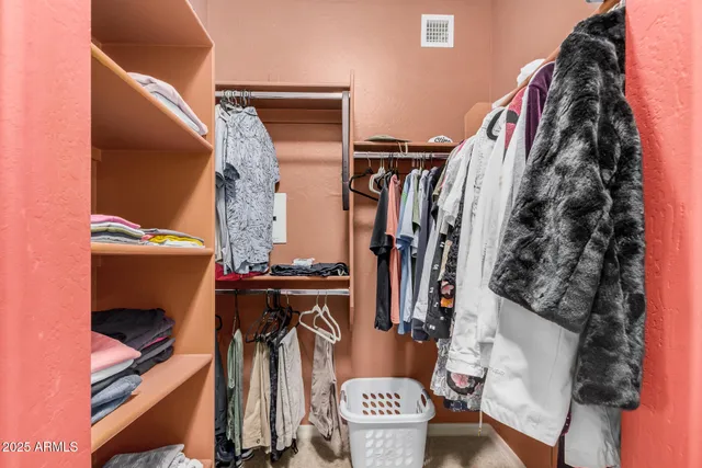 a view of walk in closet with clothes and shoes
