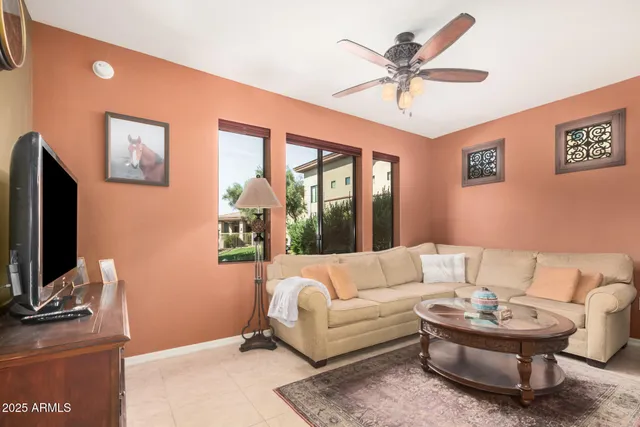 a living room with furniture a desk and a flat screen tv