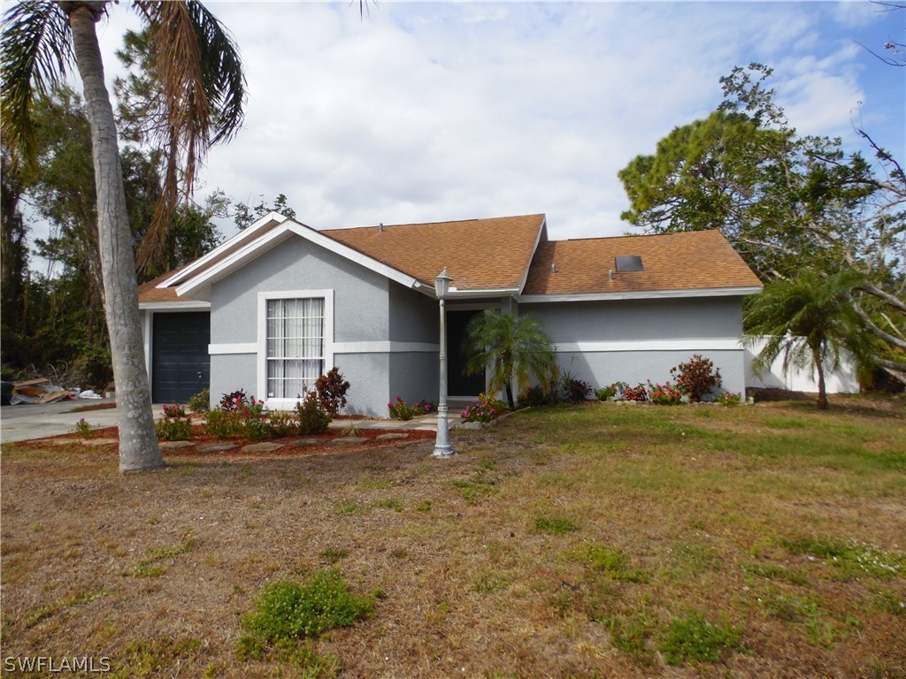17412 Oriole Road Fort Myers, FL 33967 - Photo 3 of 24 a front view of house with yard and trees in the background