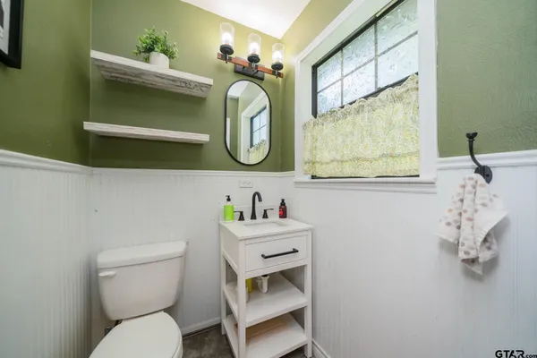 a bathroom with a toilet sink and mirror