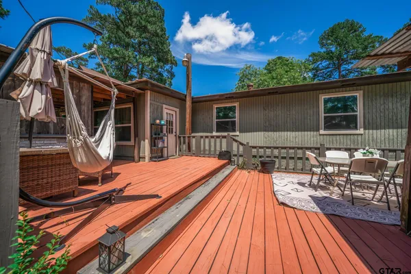 a backyard of a house with wooden floor potted plants and outdoor seating