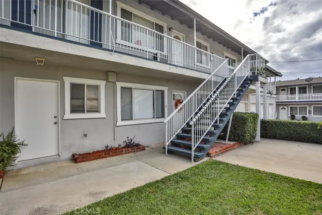 a view of a house with a small yard and wooden fence