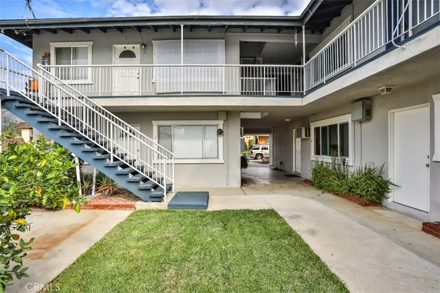 a view of a house with brick walls and a yard with plants