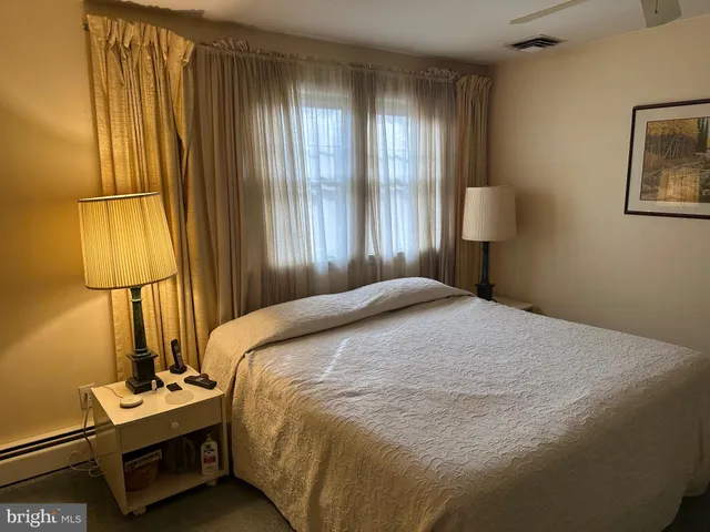 a bedroom with a bed and a night stand next to a window