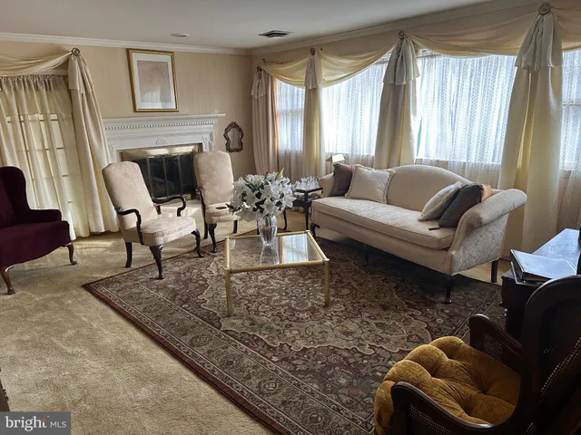 a living room with furniture a fireplace and a large window