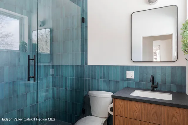 a bathroom with a sink a toilet and mirror