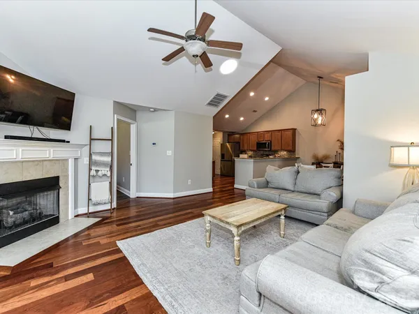 a living room with furniture a flat screen tv and a fireplace