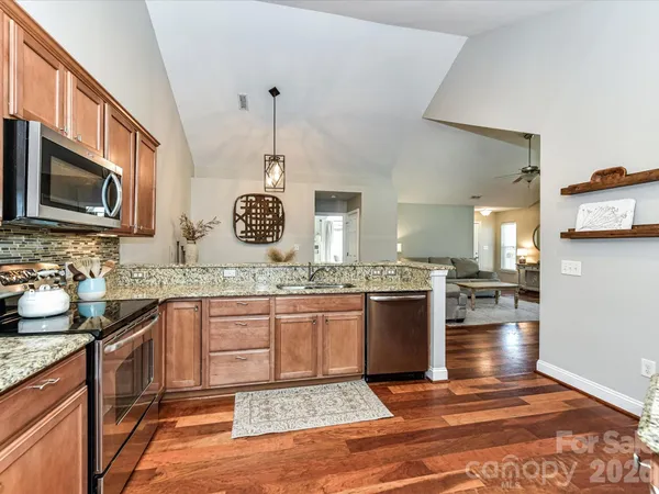 a kitchen with stainless steel appliances granite countertop a sink stove and cabinets
