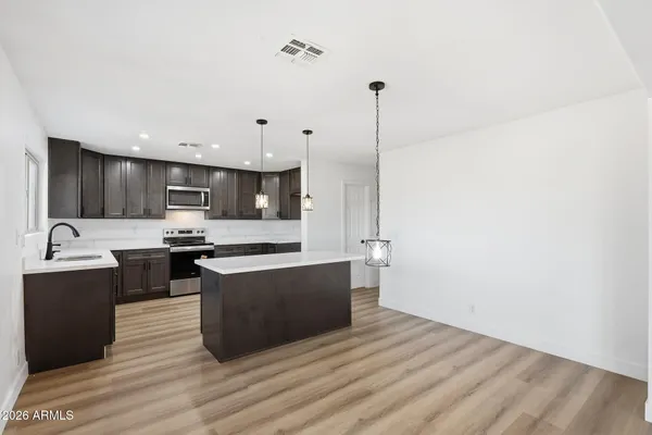 a kitchen with stainless steel appliances a sink cabinets and wooden floor