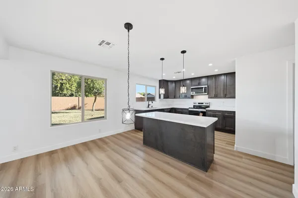 a kitchen with stainless steel appliances granite countertop a sink a stove and a wooden floors