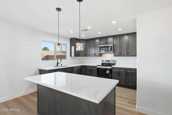 a large kitchen with kitchen island a sink stainless steel appliances and cabinets