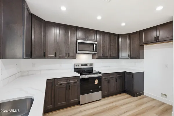 a kitchen with granite countertop stainless steel appliances and wooden cabinets