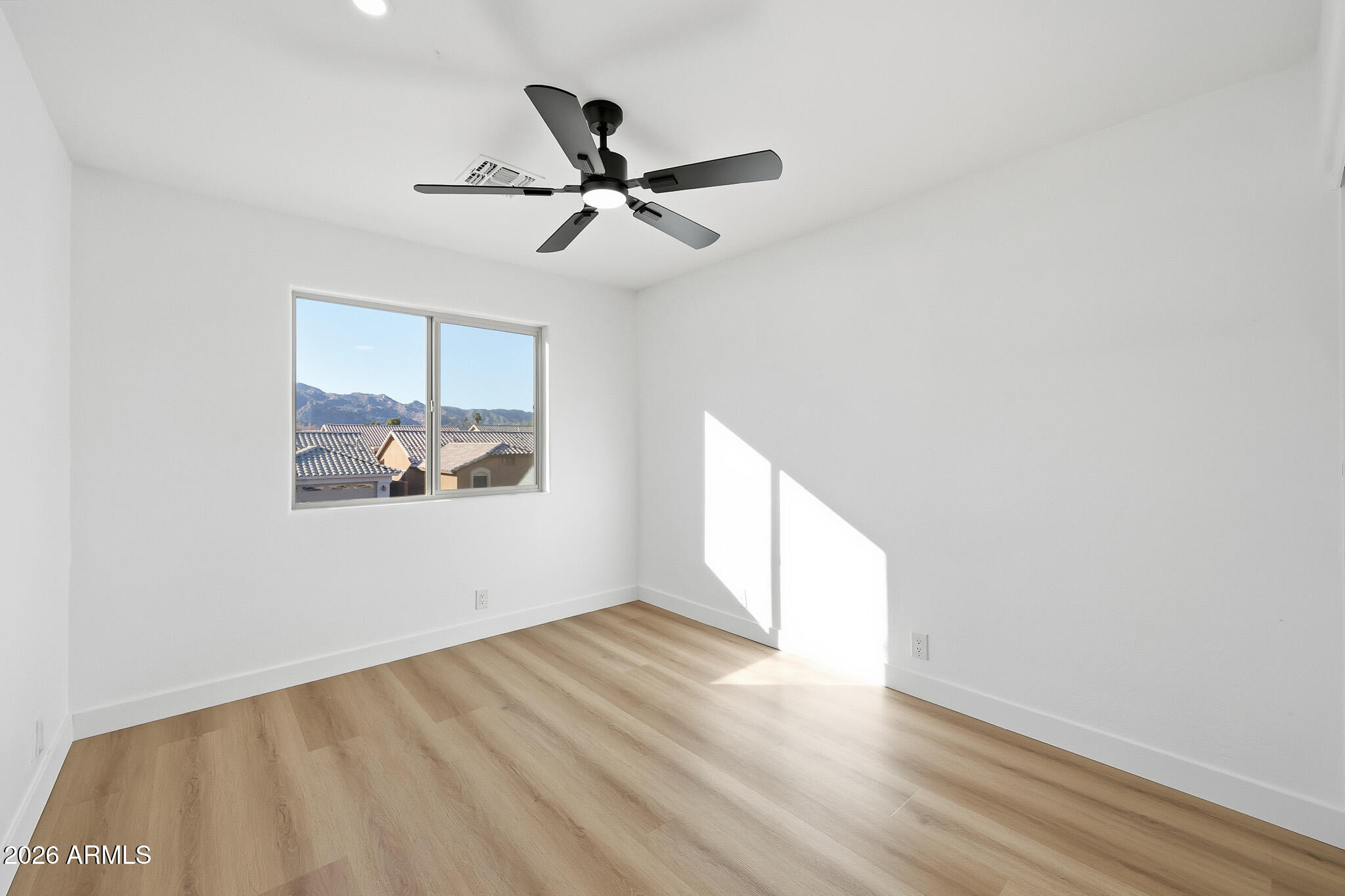 916 East Harwell Road Phoenix, AZ 85042 - Photo 20 of 27 a view of empty room with wooden floor and fan