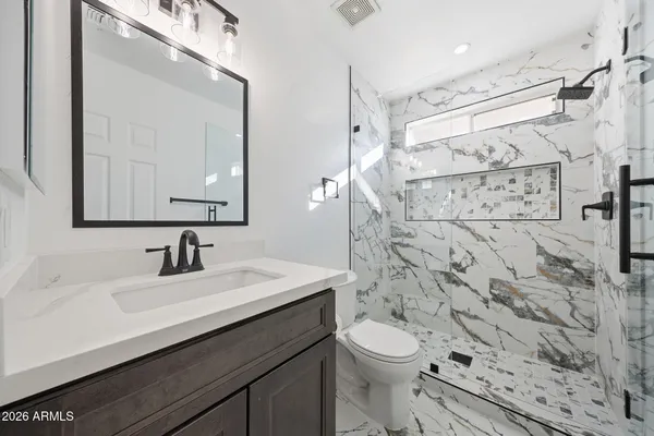 a bathroom with a sink toilet vanity and shower