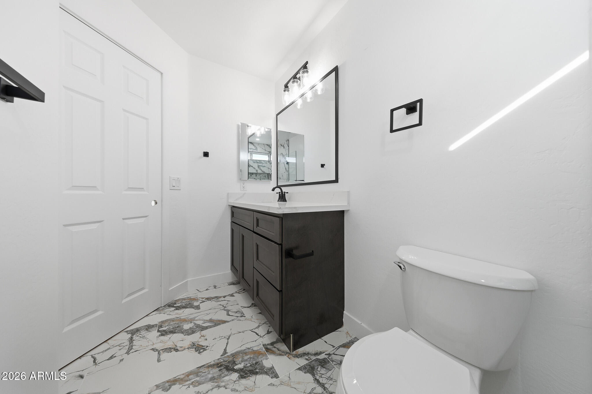 916 East Harwell Road Phoenix, AZ 85042 - Photo 23 of 27 a bathroom with a toilet sink and mirror