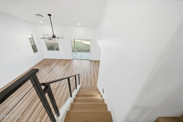 a view of a hallway with wooden floor and staircase