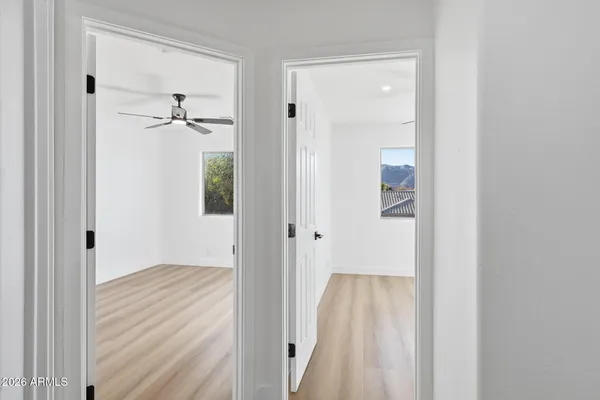 a view of a hallway with wooden floor and closet area