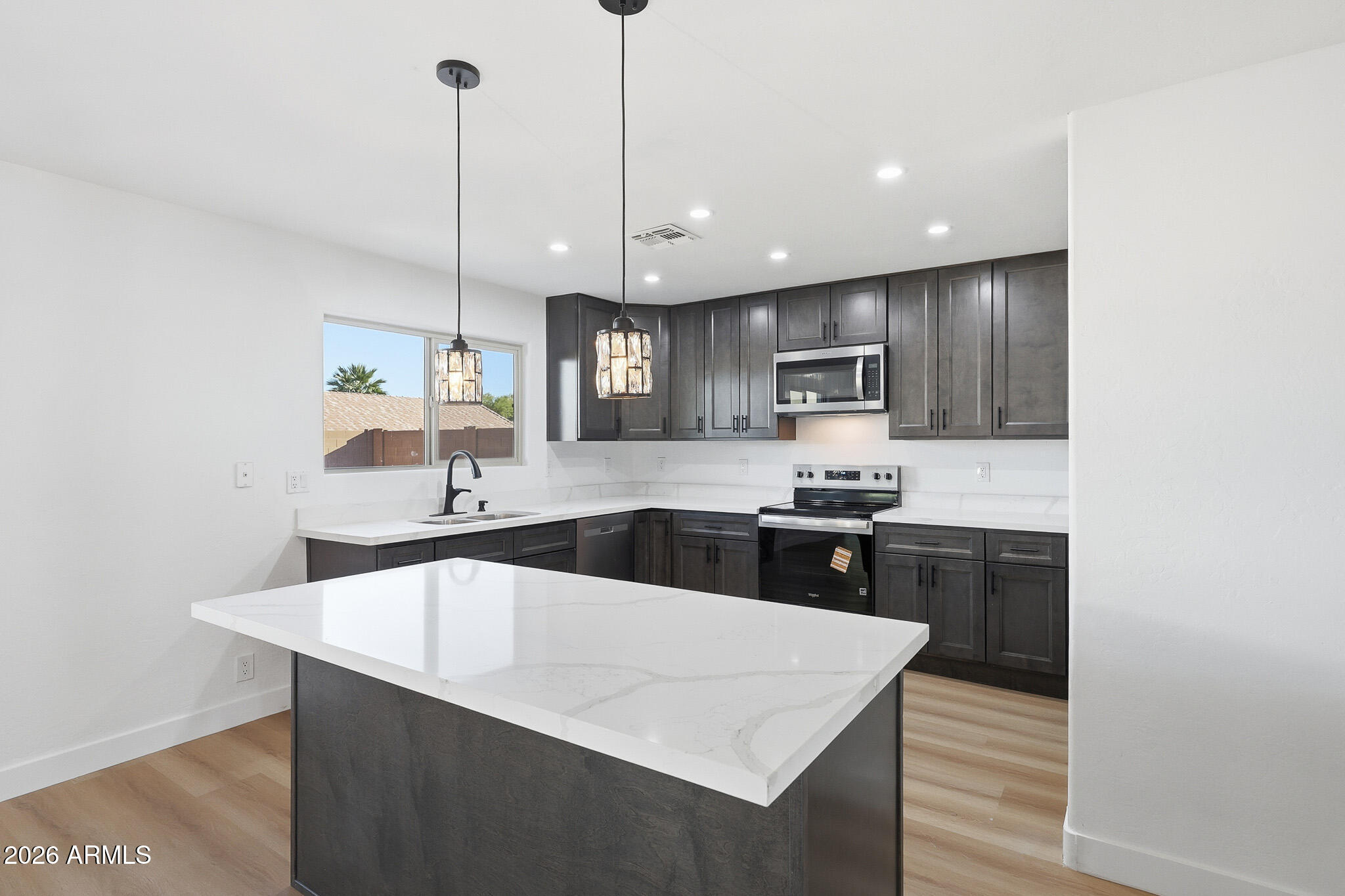 916 East Harwell Road Phoenix, AZ 85042 - Photo 5 of 27 a large kitchen with kitchen island a sink stainless steel appliances and cabinets