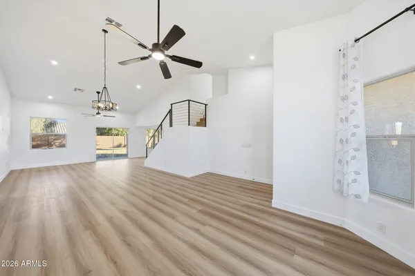 a view of an empty room with window and wooden floor