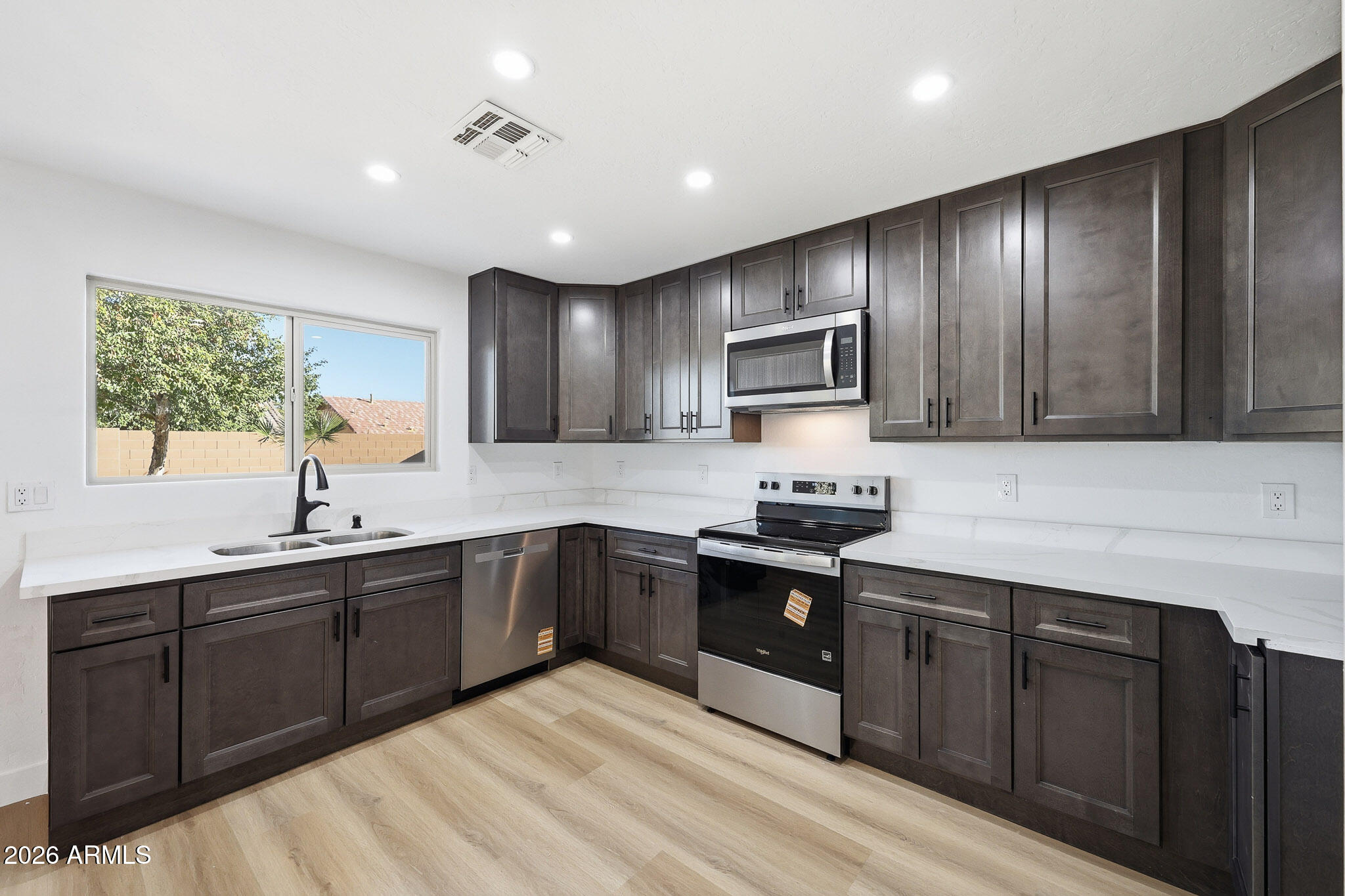 916 East Harwell Road Phoenix, AZ 85042 - Photo 7 of 27 a kitchen with wooden cabinets and sink