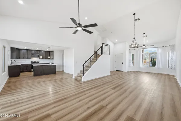 a view of a livingroom with wooden floor and staircase