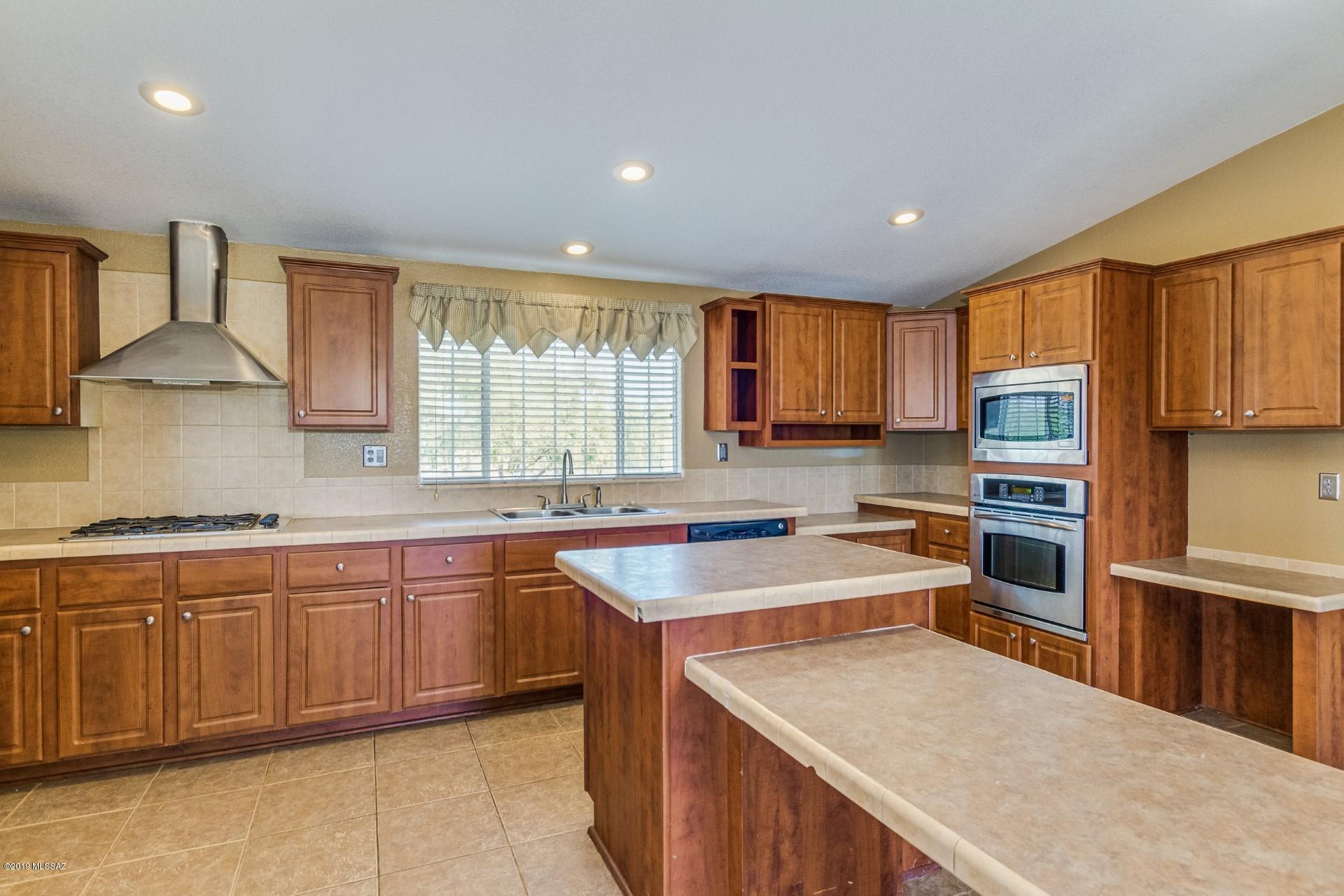 8945 West Bopp Road Tucson, AZ 85735 - Photo 4 of 21 a kitchen with stainless steel appliances granite countertop sink stove top oven and cabinets