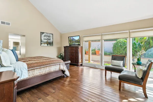a bedroom with a bed a couch and a large window