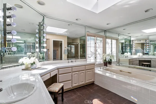 a large white kitchen with a large window and stainless steel appliances
