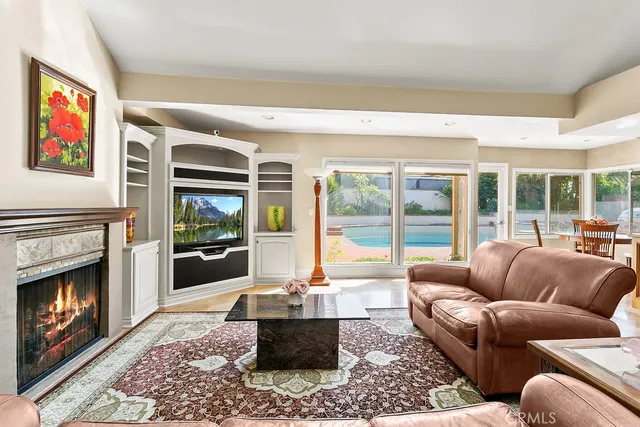 a living room with furniture a floor to ceiling window and a fireplace