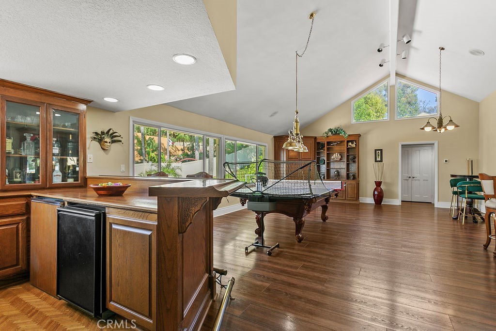 18811 Ridgeview Circle Villa Park, CA 92861 - Photo 26 of 34 a kitchen with stainless steel appliances granite countertop a stove top oven a dining table and chairs with wooden floor