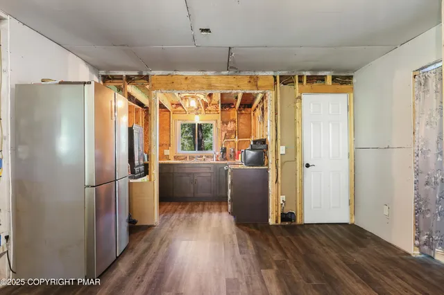 a kitchen with stainless steel appliances a refrigerator and wooden floor