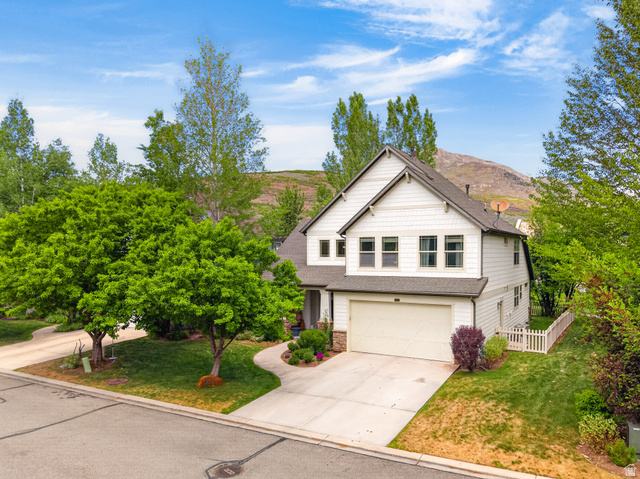 557 Craftsman Way Midway, UT 84049 - Photo 2 of 59 White siding exterior with a prominent two-car garage, established front yard landscaping, and a mountain backdrop