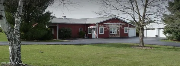 a view of a house with brick walls and a tree