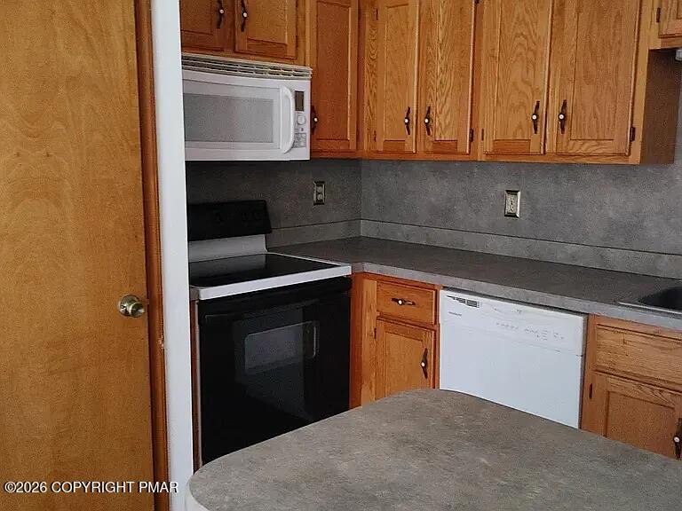 165 Old Stagecoach Road, Unit 3 Gilbert, PA 18331 - Photo 13 of 20 a kitchen with stainless steel appliances granite countertop a stove a sink and a microwave